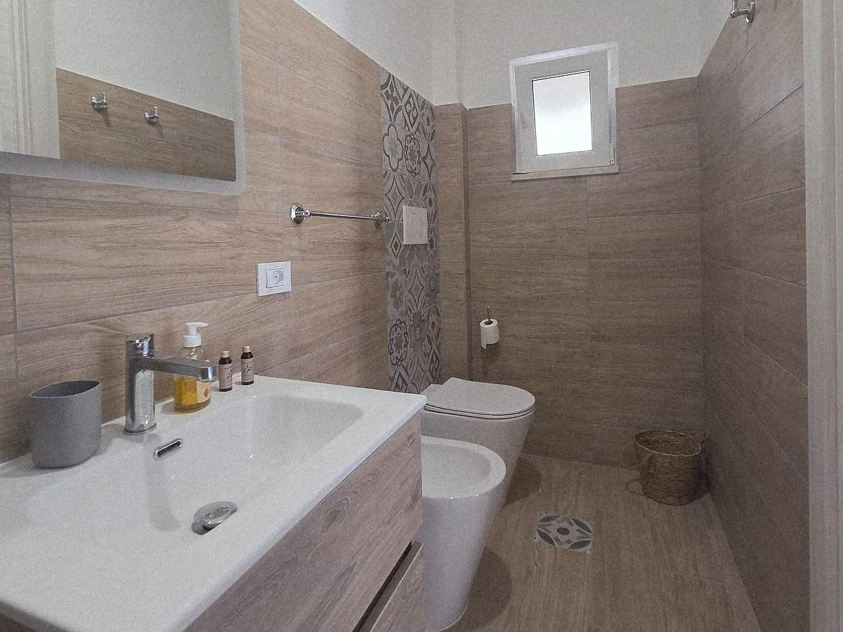Bagno con mobile lavabo in legno e piastrelle decorate
